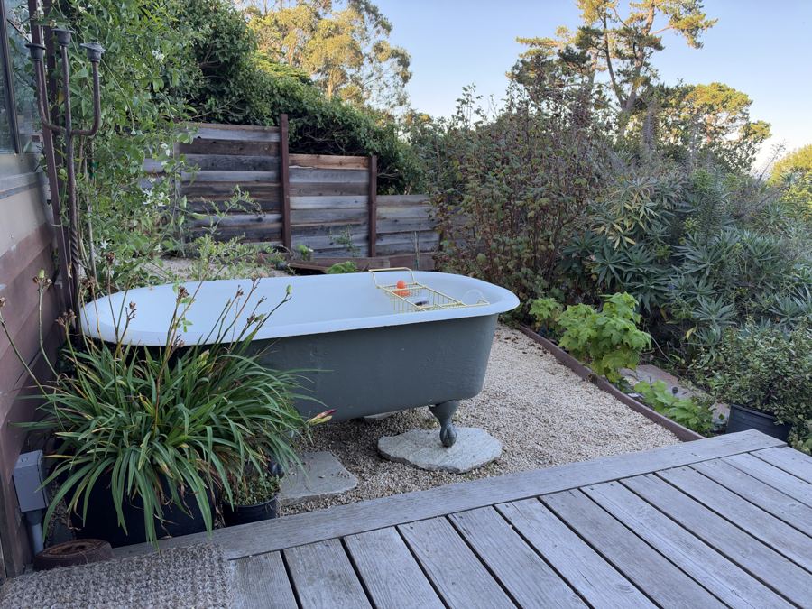 Outdoor clawfoot tub on a gravel terrace